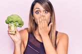 Shocked woman holding broccoli