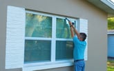 Weatherproofing or winterizing a window, sealing leaks with a caulk gun