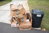Empty Amazon boxes sitting on the curb with the trash on garbage day