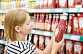 Woman checking out ketchup bottle