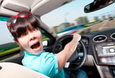 Panicking woman driving a car and clutching steering wheel on the highway