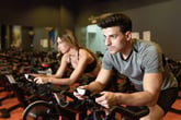 Man and woman doing cycling exercise in the gym