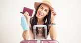 Winking woman traveler with passport and airplane ticket and carry-on luggage
