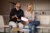 Confused stressed older couple looking at bill or credit statement
