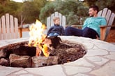 view of firepit and happy smiling family of two, father and son, enjoying time together in the background