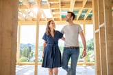 Happy couple walking through new home under construction