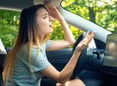 Frustrated woman or annoyed driver driving a car