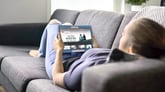 Woman laying on couch watching TV