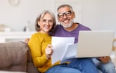 Happy senior couple homeowners doing taxes