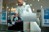 A TSA agent inspects carry-on bag luggage