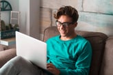 Young man in glasses using a laptop