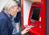 Woman using ATM shocked or surprised by her bank account balance