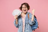 Excited young woman or college student with lots of money feeling successful