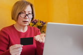 Older woman confused or annoyed with website on her laptop that won't accept her credit card payment