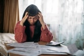 Stressed woman with a calculator paying bills or doing taxes