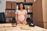 pregnant business worker prepares package order at office