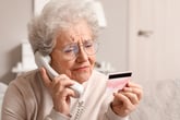 Confused senior woman on the phone with her credit card company about an usual transaction or unexpected bill