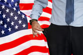 Man with empty pockets in front of the U.S. flag