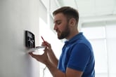 Man installing a home security system