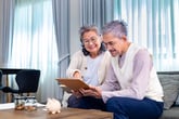 Happy retired couple checking finances or budgeting and doing financial planning for retirement