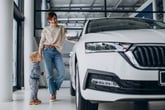 Mother shopping for a new car with young son or toddler