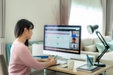 Business woman working remotely and using her computer for an online meeting, video call.