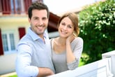Young couple standing outside a home