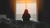 Silhouette of woman sitting in bed
