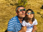 Father and daughter watching a solar eclipse