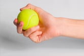Hand holding a tennis ball