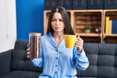 Frowning woman holding a cup of coffee