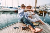 Retired couple drinking champagne on sailboat