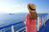 A woman on a cruise looking at the ocean.