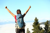 Backpacker with arms raised triumphantly