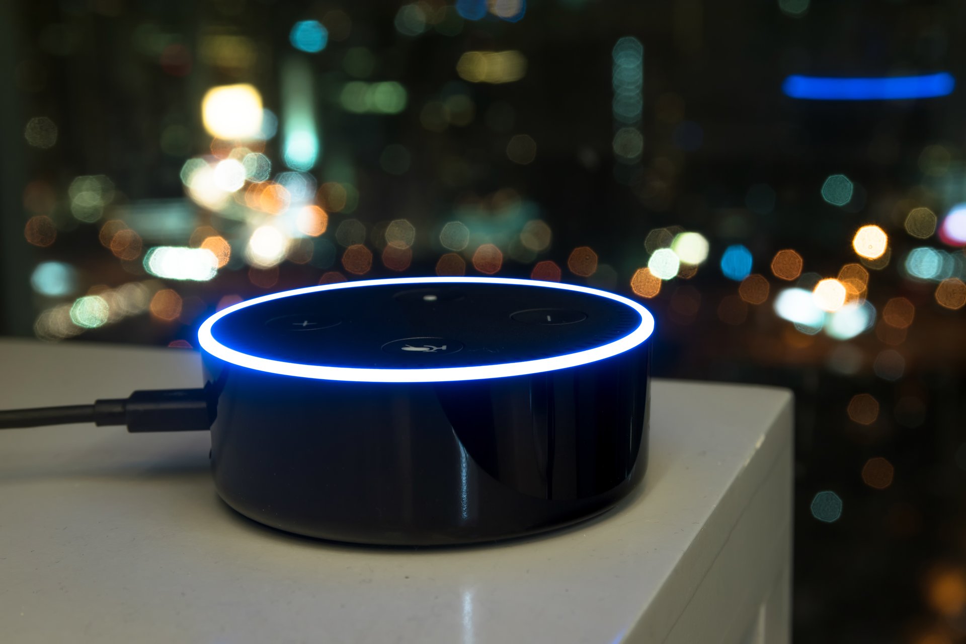 An Echo Dot device by Amazon sits on a table