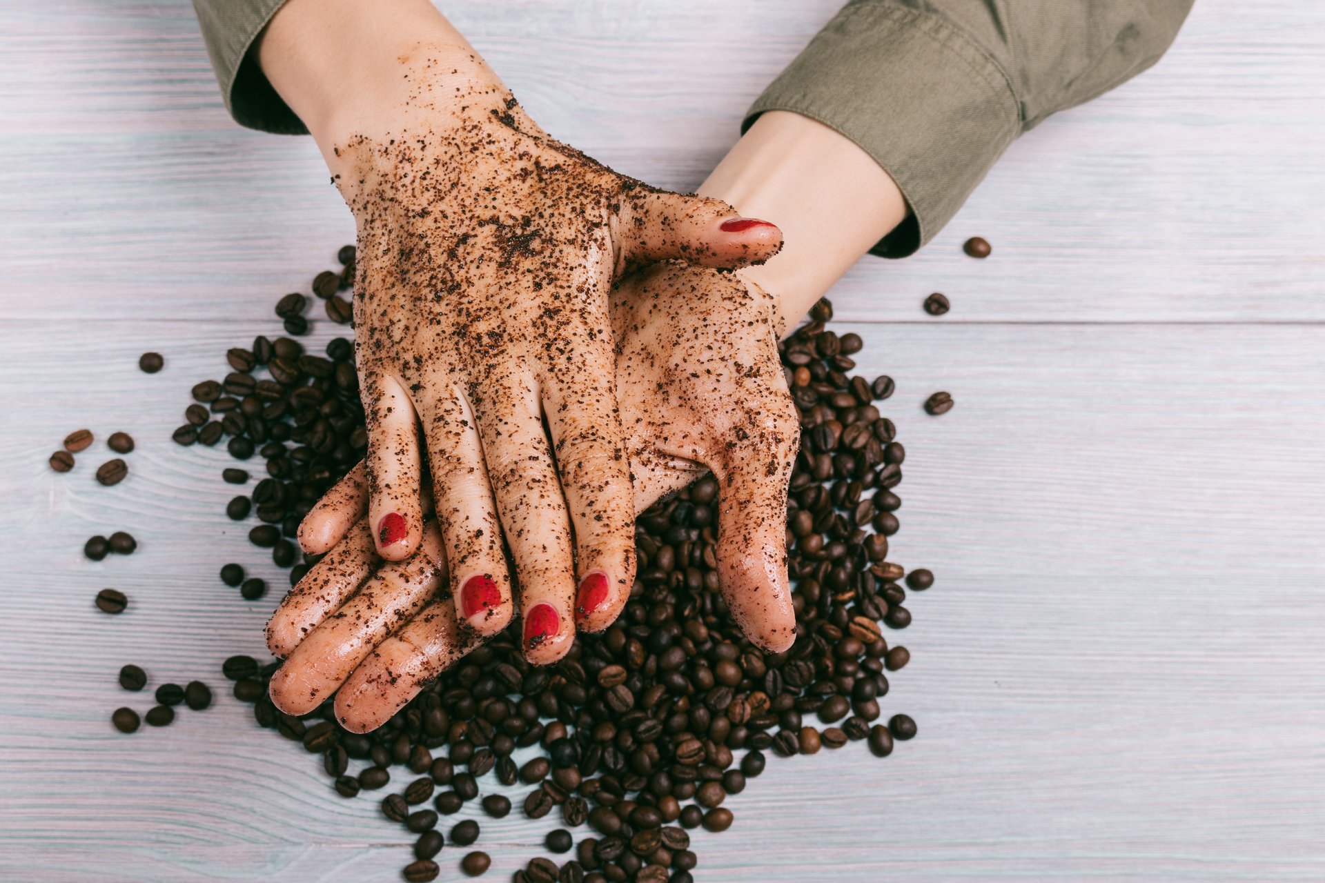 A woman scrubs her hands clean with coffee grounds
