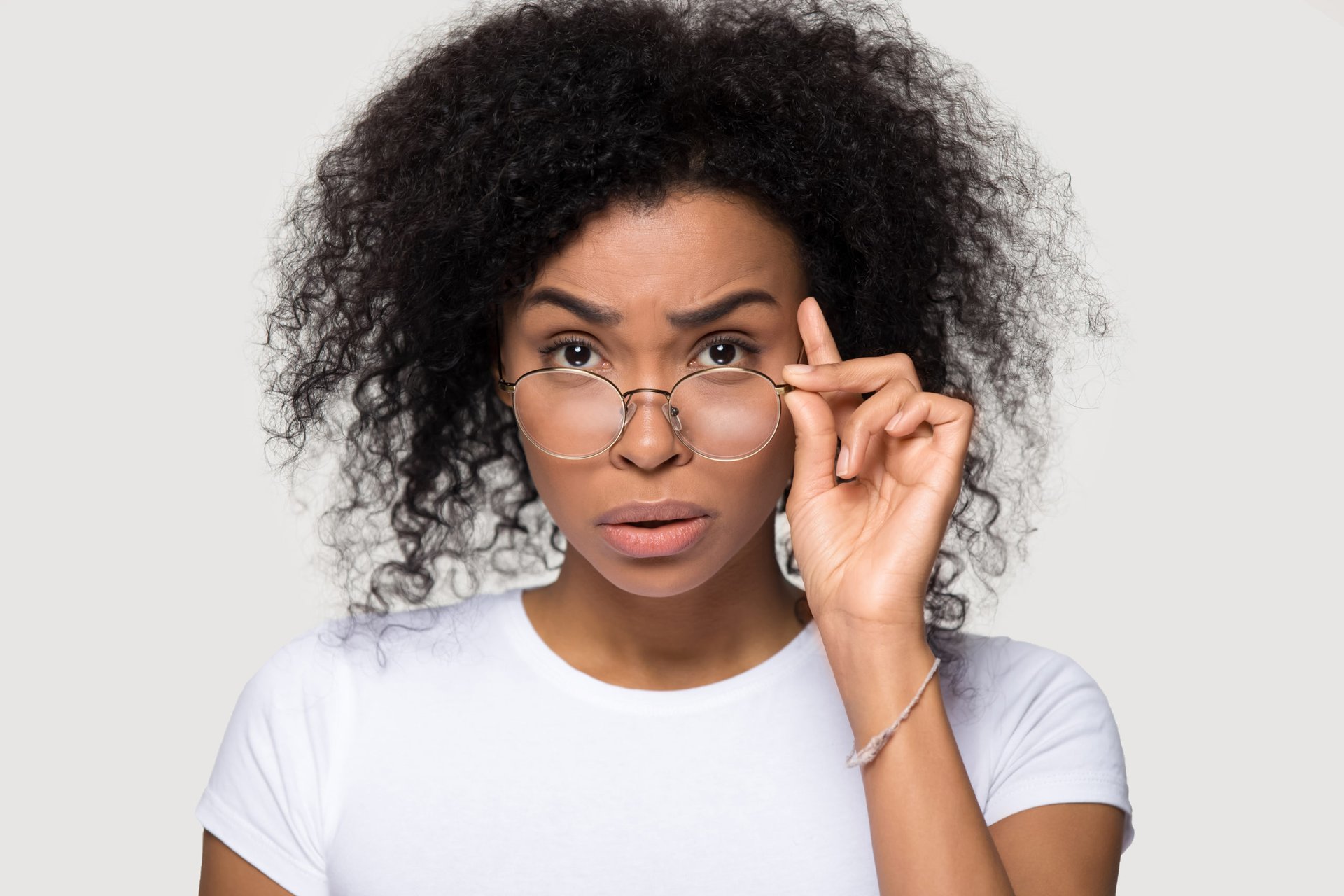 Surprised woman lowering her eyeglasses