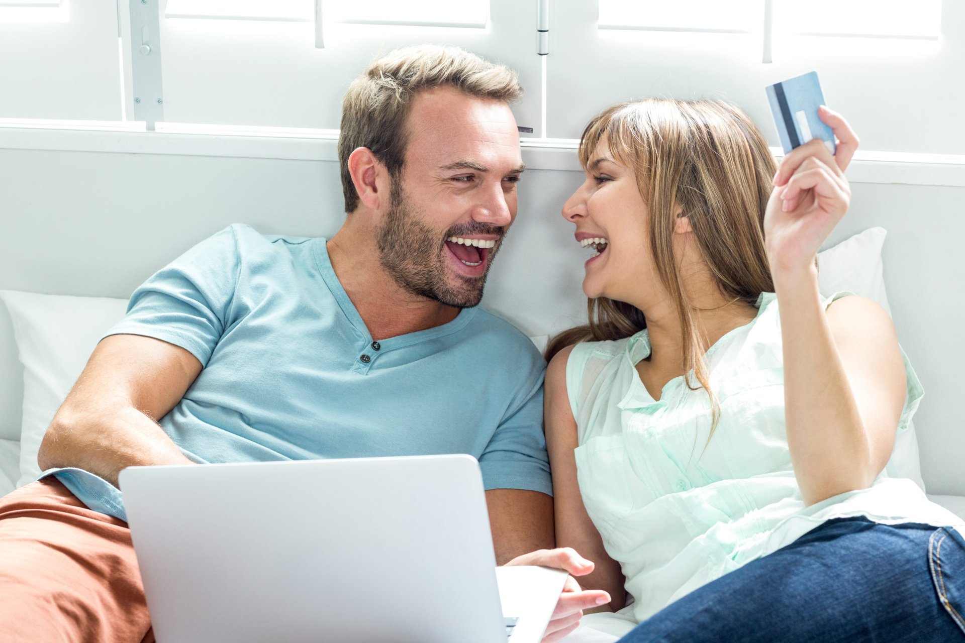 Happy couple using laptop and planning travel with credit card rewards
