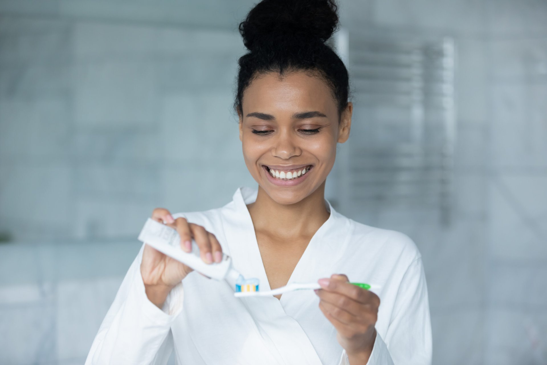 Woman putting toothpaste on a toothbrush