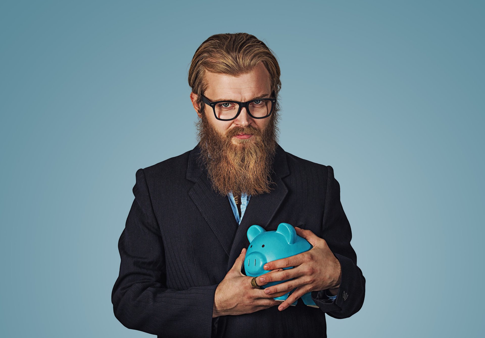 A greedy businessman in glasses clings to his piggy bank