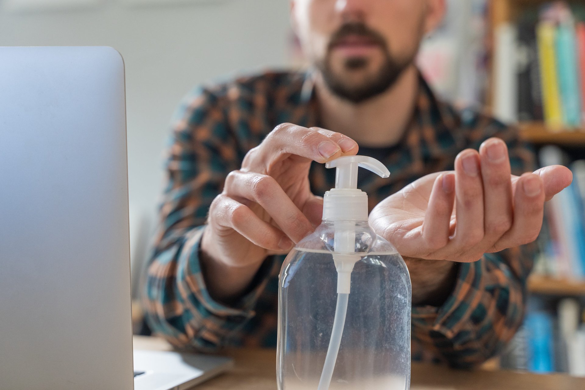 A man uses hand sanitizer while working from home due to the coronavirus pandemic