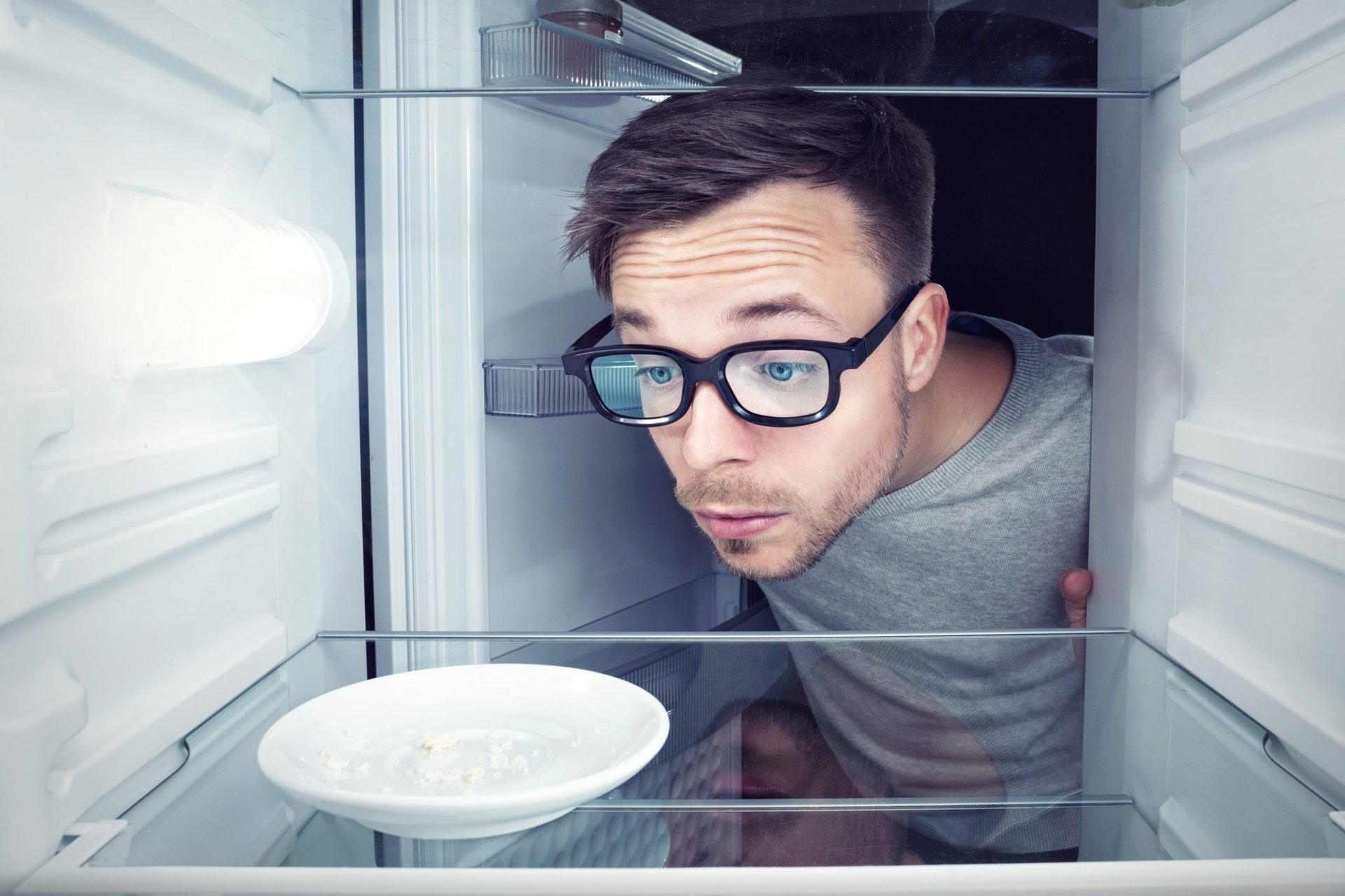 Man looking into an empty refrigerator
