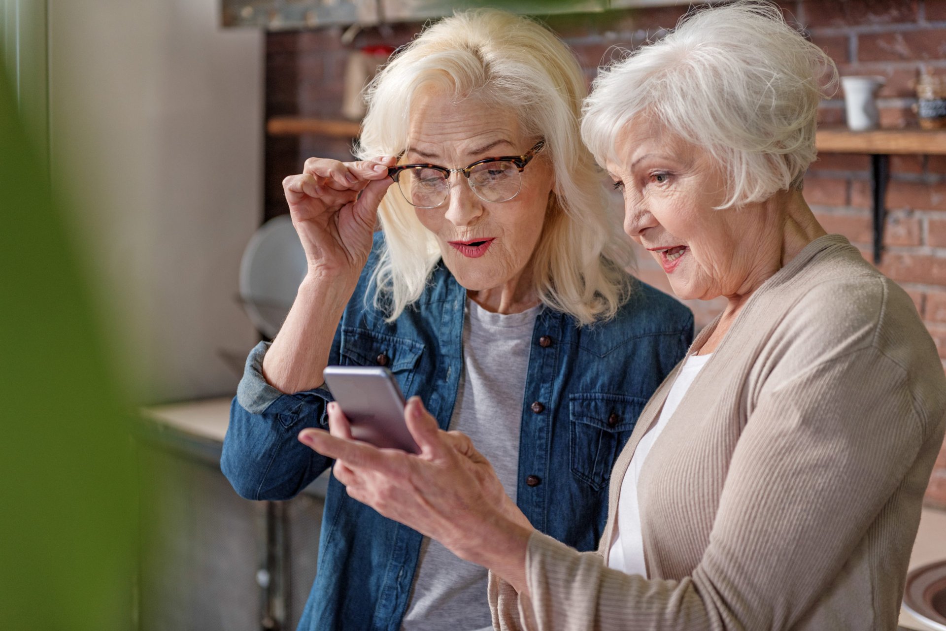 Two older women look at a smartphone