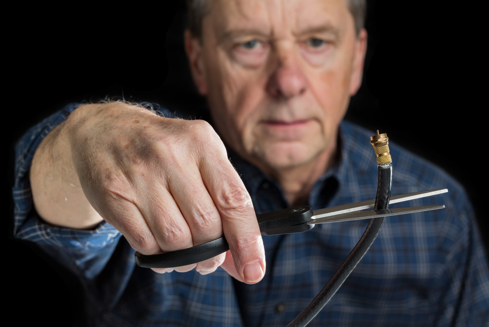 Older man cutting the cord and cancelling cable TV
