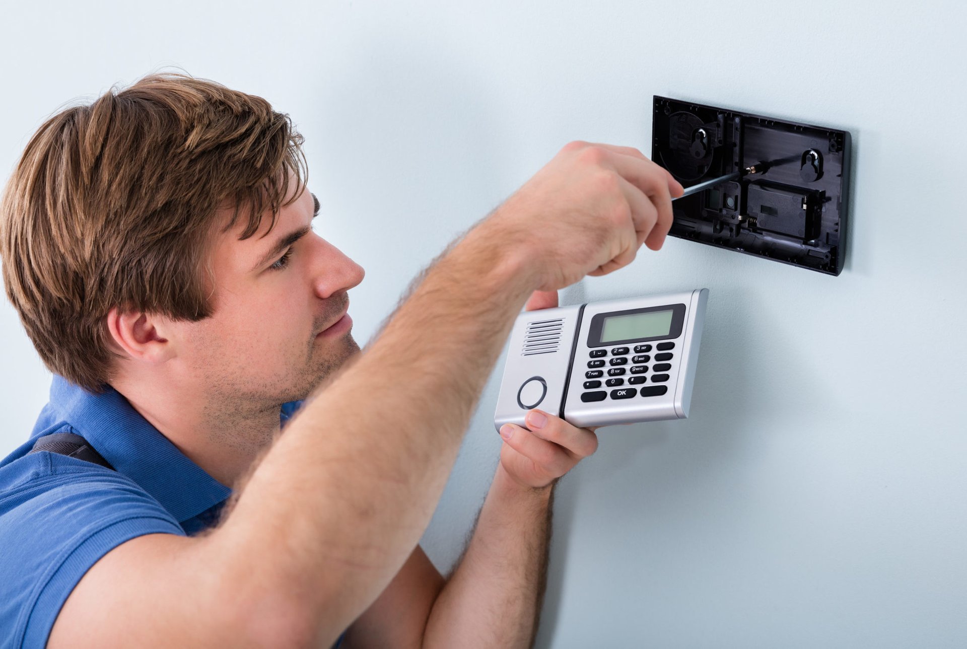 Worker installing a home security system