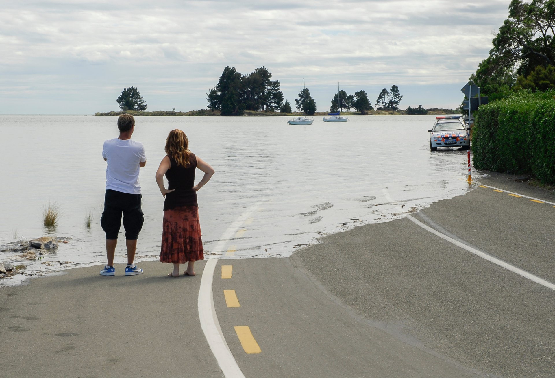 people looking at water over road, rising sea levels, climate change