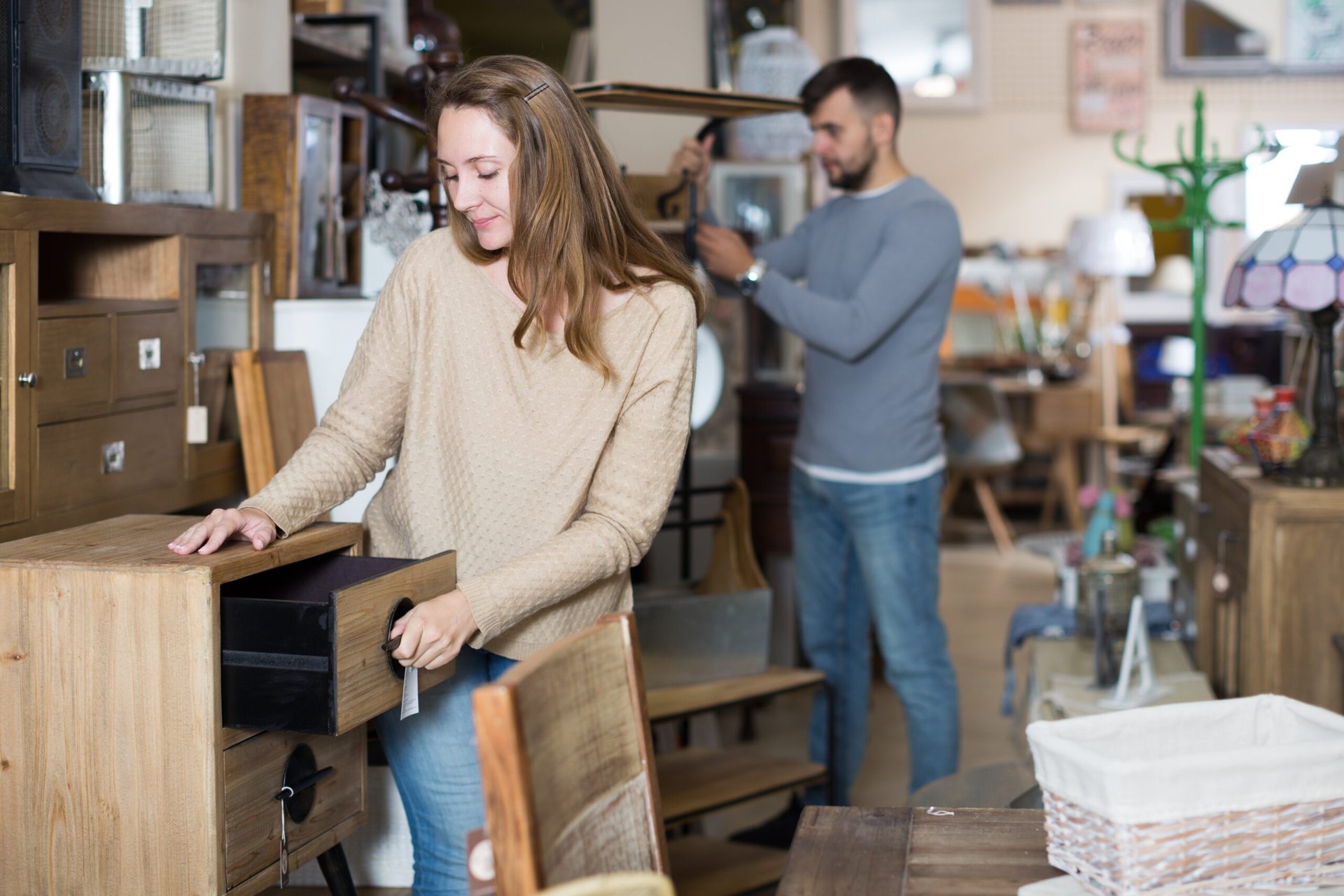 Couple looking for furniture in second hand shop