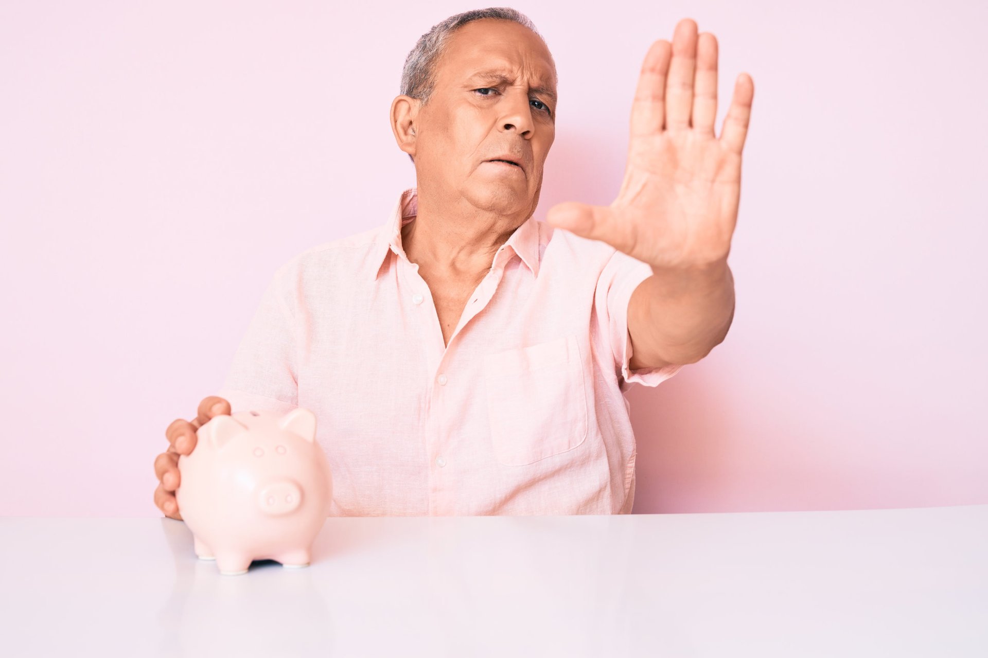 Senior man gesturing stop to protect his money