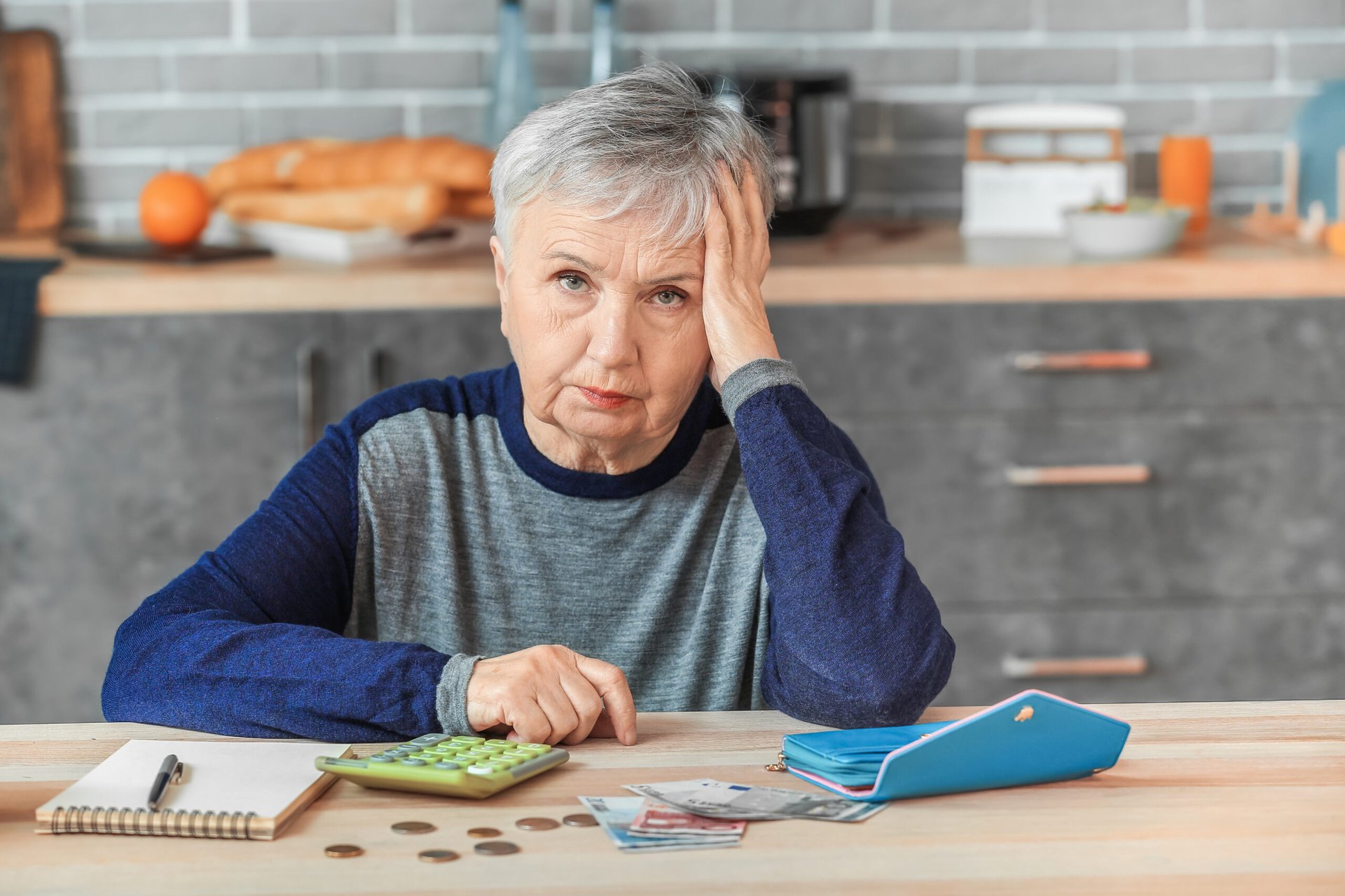 Unhappy senior woman counts money