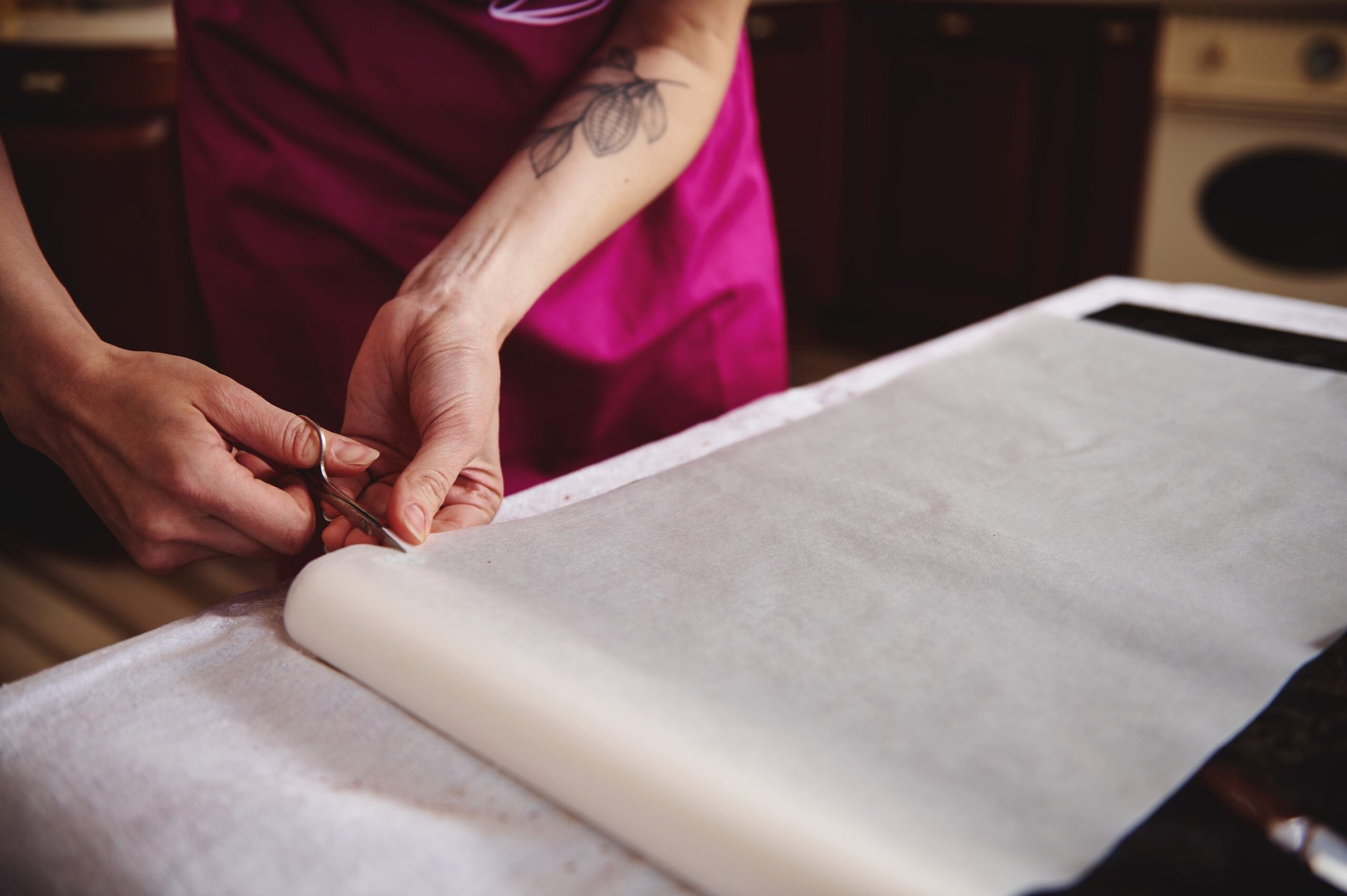 Woman cutting a sheet of parchment paper
